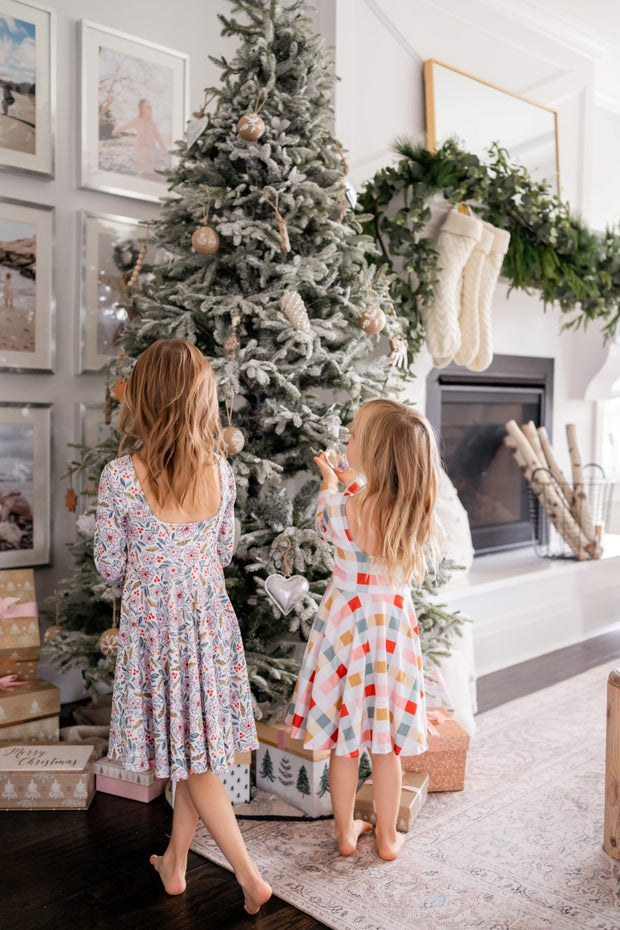 Girls coordinating Christmas twirl dresses in a bright and cheery watercolor floral and coordinating gingham
